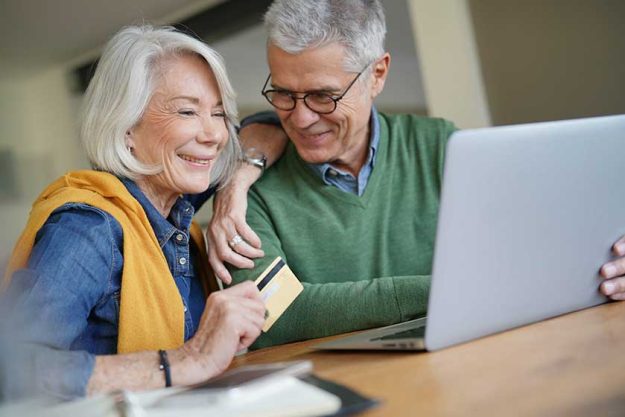 Happy senior couple online shopping at home Happy senior couple online shopping at home