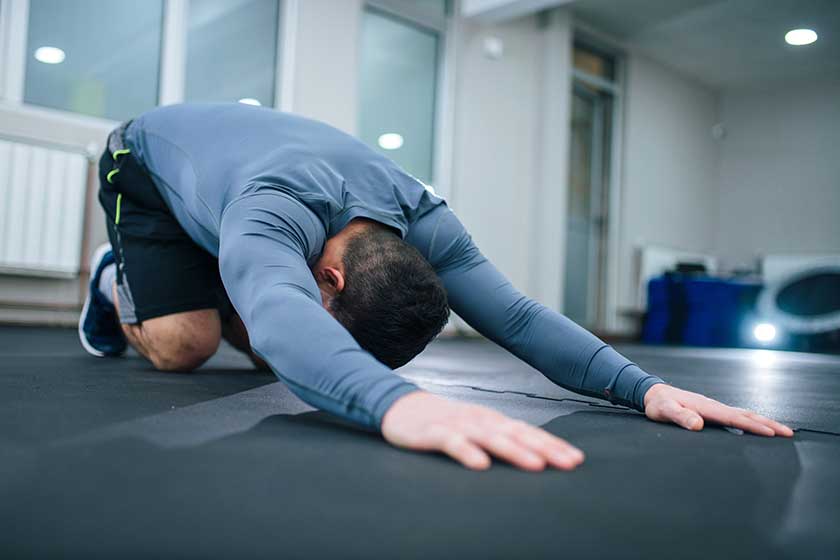 Low angle image of muscular man stretching back indoors. Low angle image of muscular man stretching back indoors.