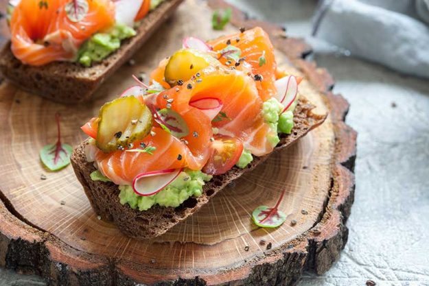 Smorrebrod with salmon on rye bread with vegetables and herbs Smorrebrod with salmon on rye bread with vegetables and herbs