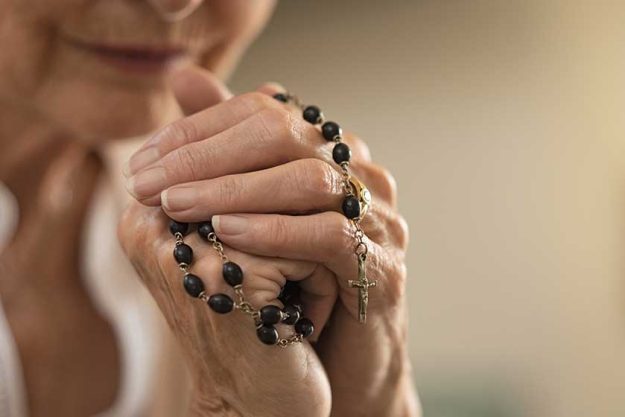 Hands holding rosary and praying Hands holding rosary and praying