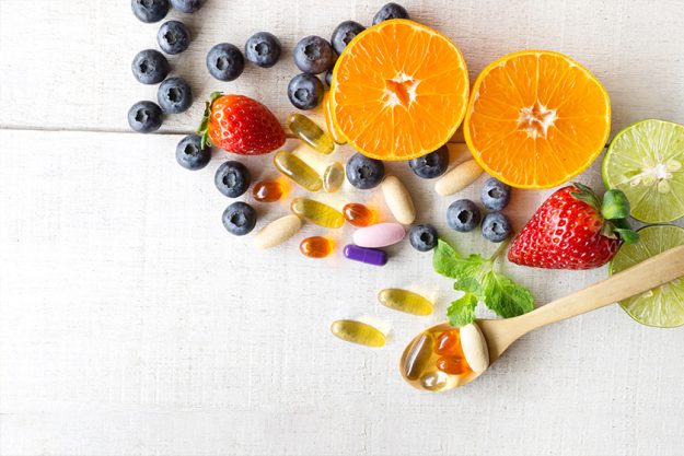 Multivitamins and supplements with fresh and healthy fruits Multivitamins and supplements with fresh and healthy fruits