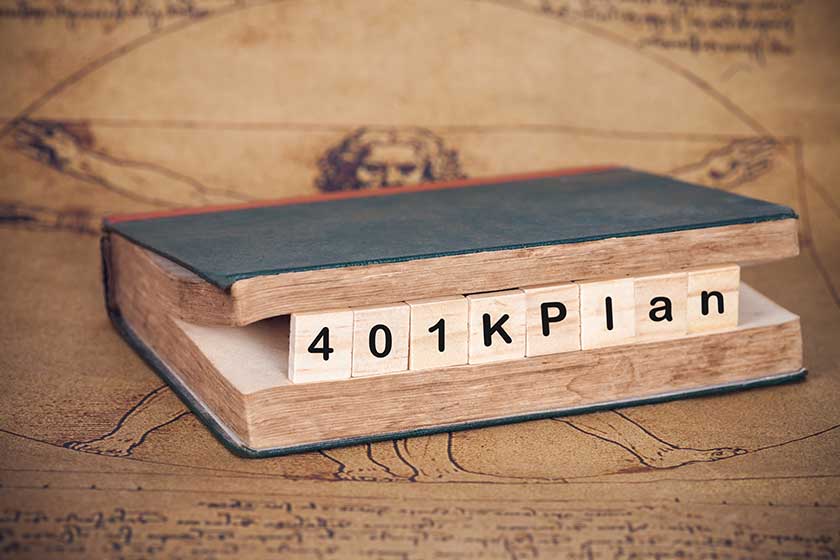 401 k Plan text on wood cube with old book ,business concept. 401 k Plan text on wood cube with old book ,business concept.