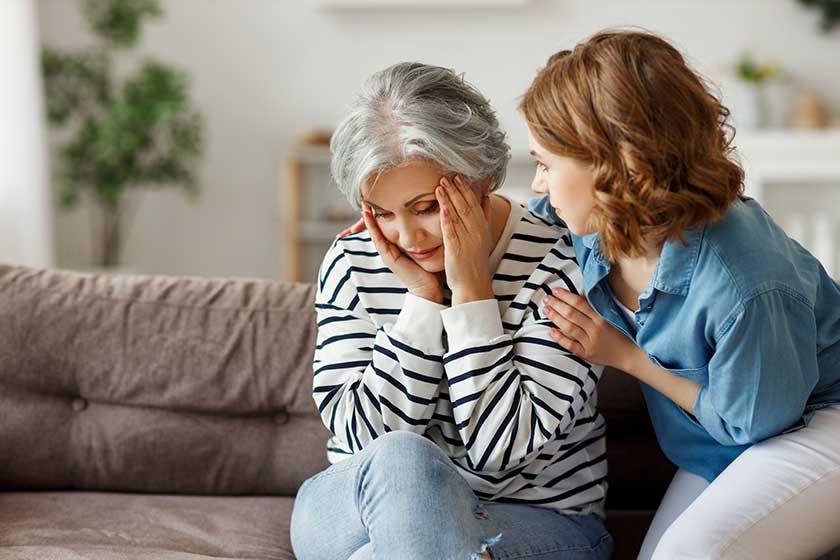 Young woman hugging and comforting sad senior Young woman hugging and comforting sad senior