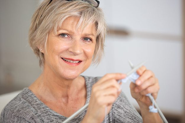 Elderly woman enjoying sewing at home