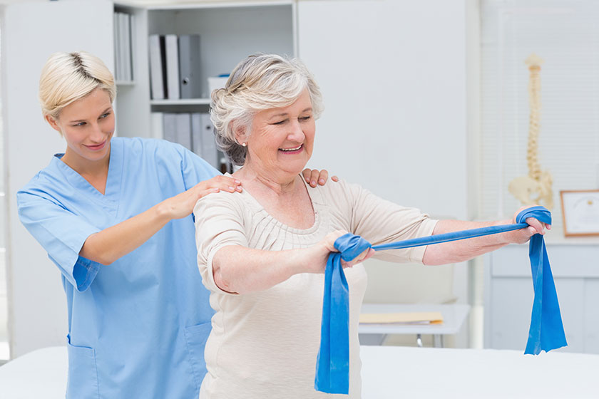 Nurse assisting senior patient in exercising