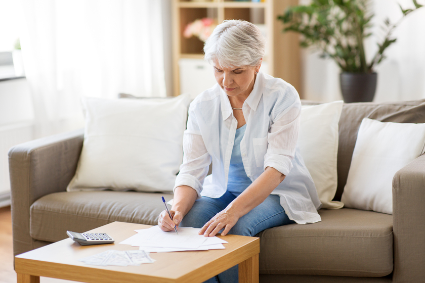 senior woman with papers and calculator at home Why Planning For Senior Home Living In Norristown, PA Earlier Is Important