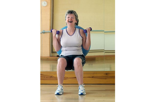 Woman exercising with weights at gym Woman exercising with weights at gym