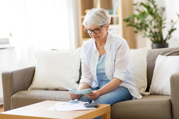 Senior woman counting money at home
