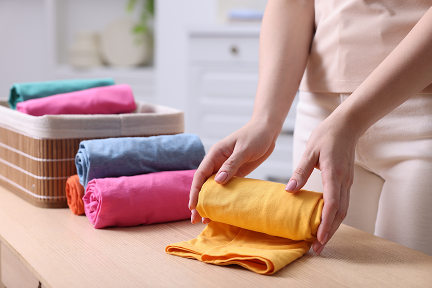 woman-rolling-shirt-table-room-closeup woman-rolling-shirt-table-room-closeup
