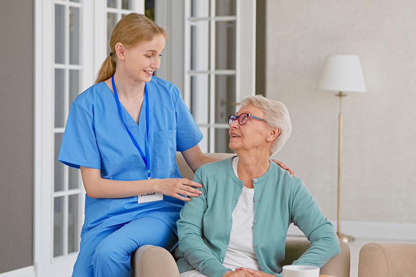 cheerful-nurse-in-uniform-listens-to-senior-patient