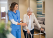 Lovely nurse helping old woman to walk