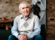 Sad elderly man sitting on sofa during self isolation