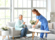 Senior woman and caregiver putting bouquet of flowers