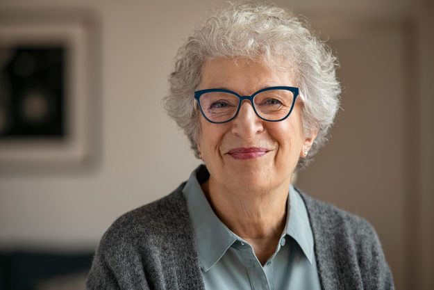 Portrait,Of,Happy,Retired,Senior,Woman,Looking,At,Camera,While