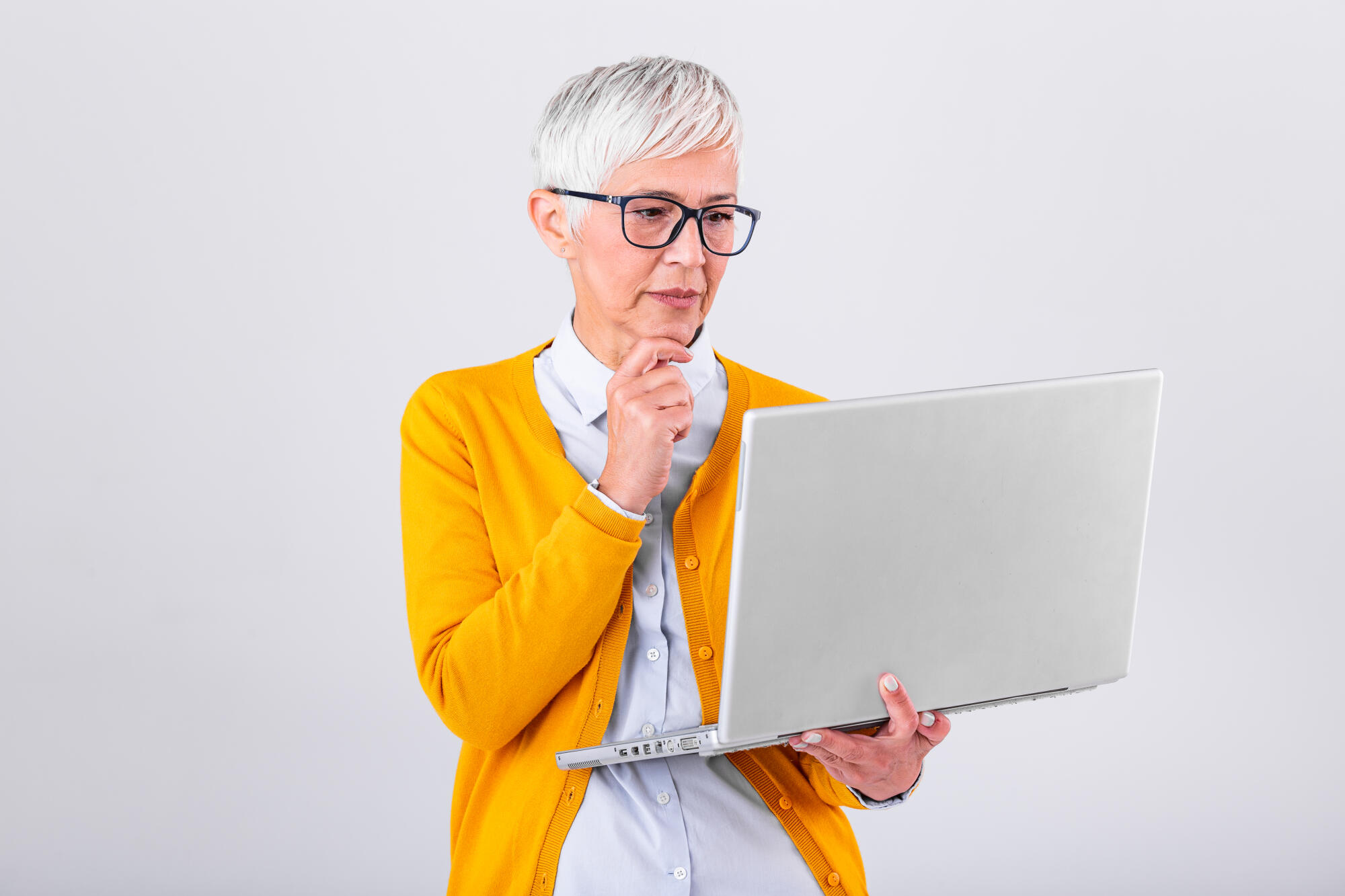 Thoughtful confused mature business woman concerned thinking about online problem looking at laptop, frustrated worried senior middle aged female reading bad email news, suffering from memory loss